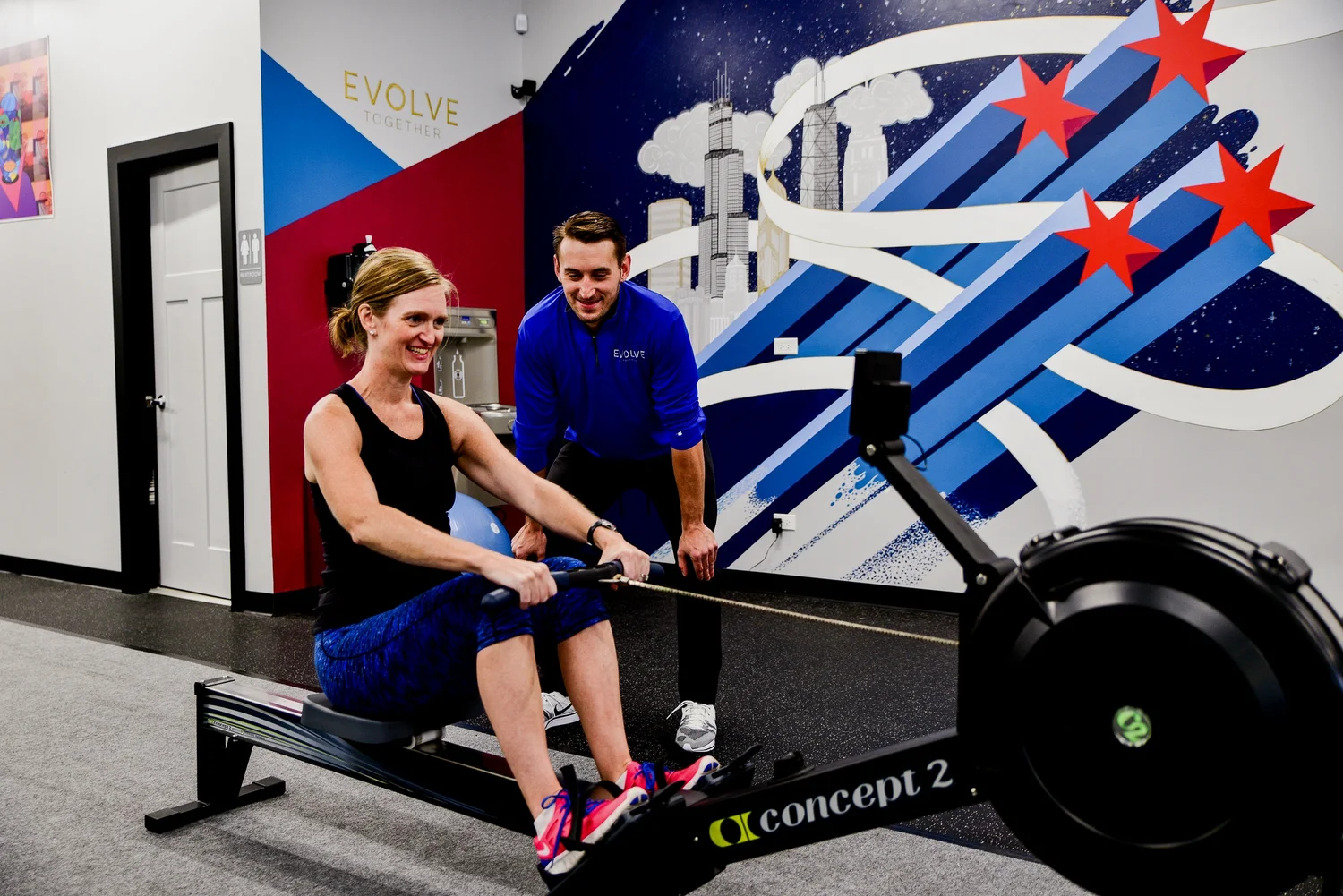An Evolve trainer coaching a client through a set on the studio floor in Lakeview, Chicago